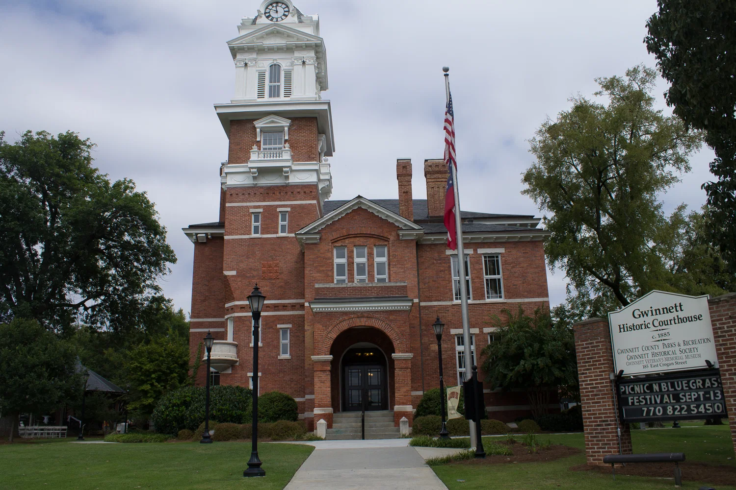 Gwinnett Historic Courthouse in Lawrenceville, Georgia, with the courthouse sign and flag in front.